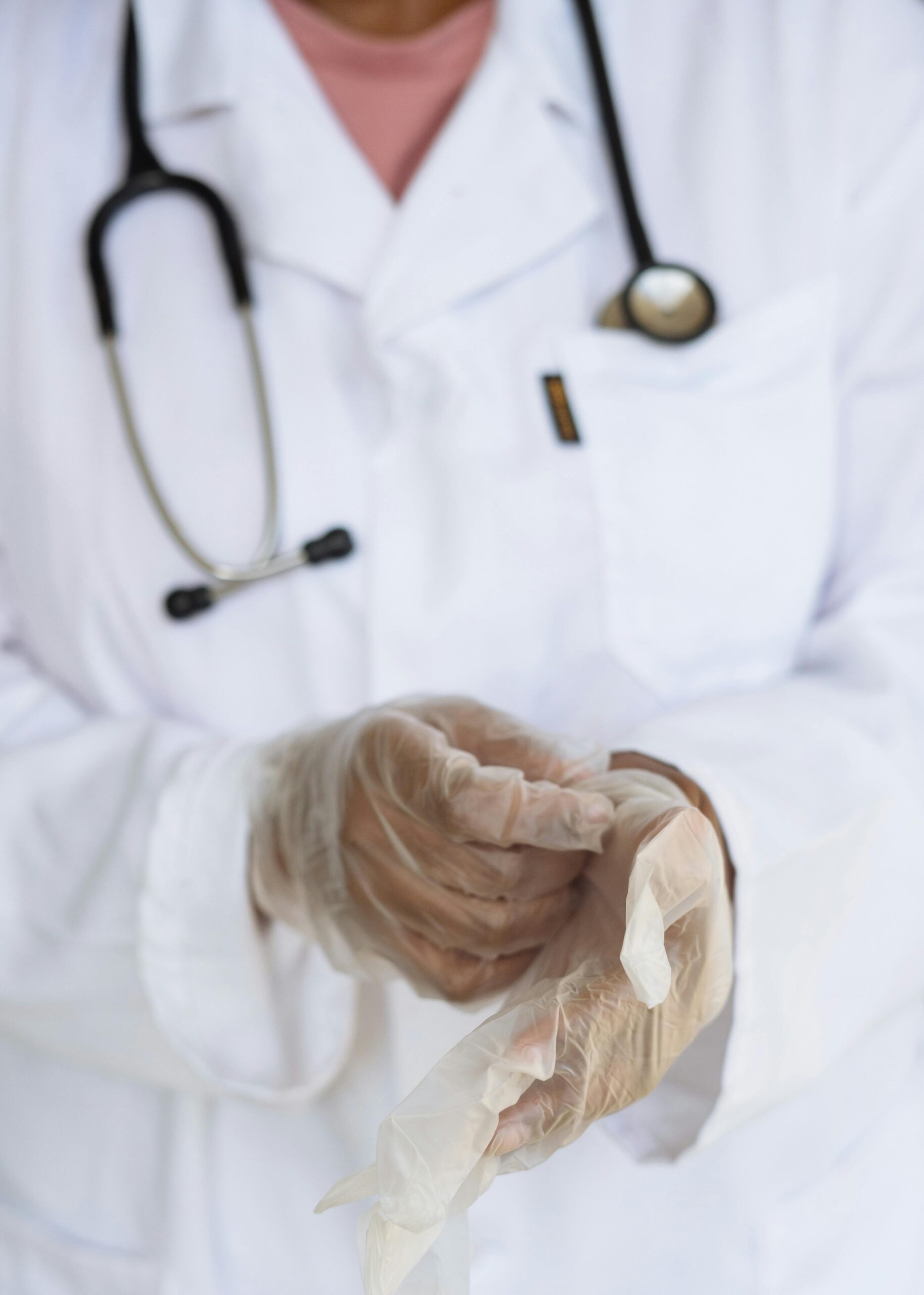 A doctor putting white latex gloves on his hands.